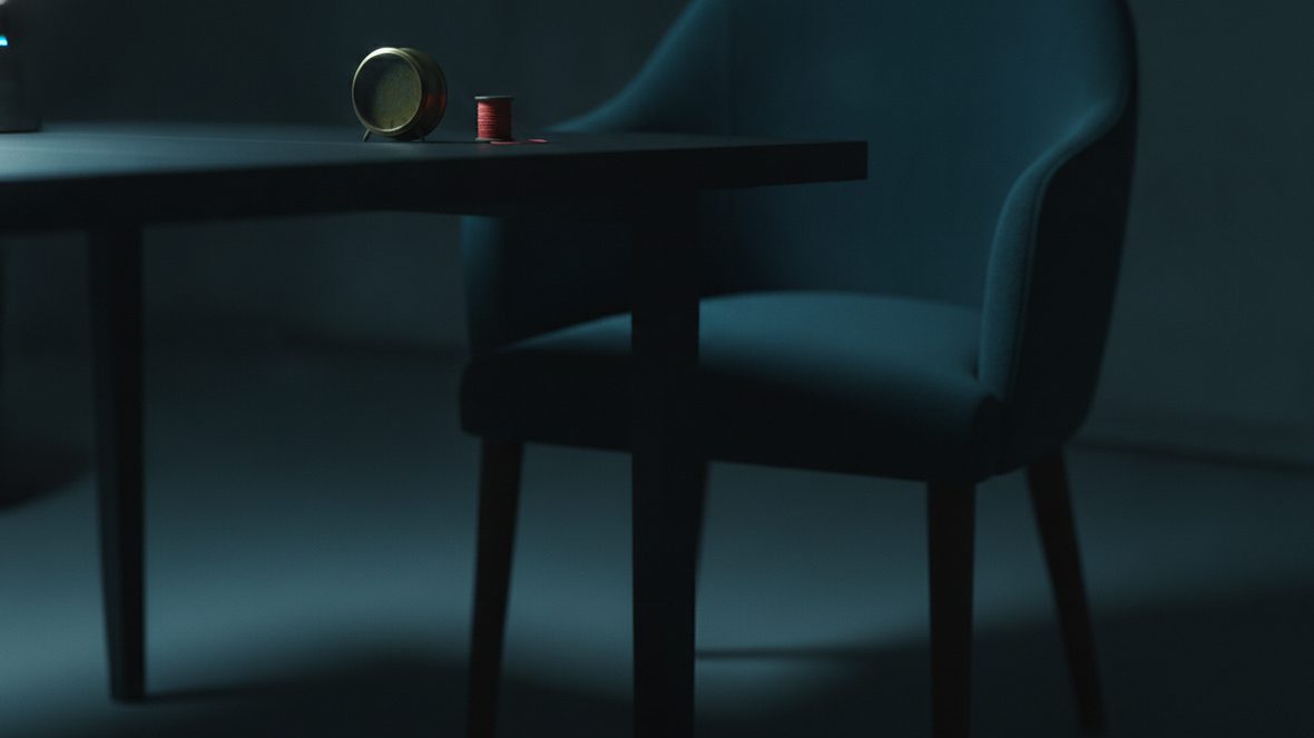 Petit réveil de laiton posé face contre table dans une pièce sombre